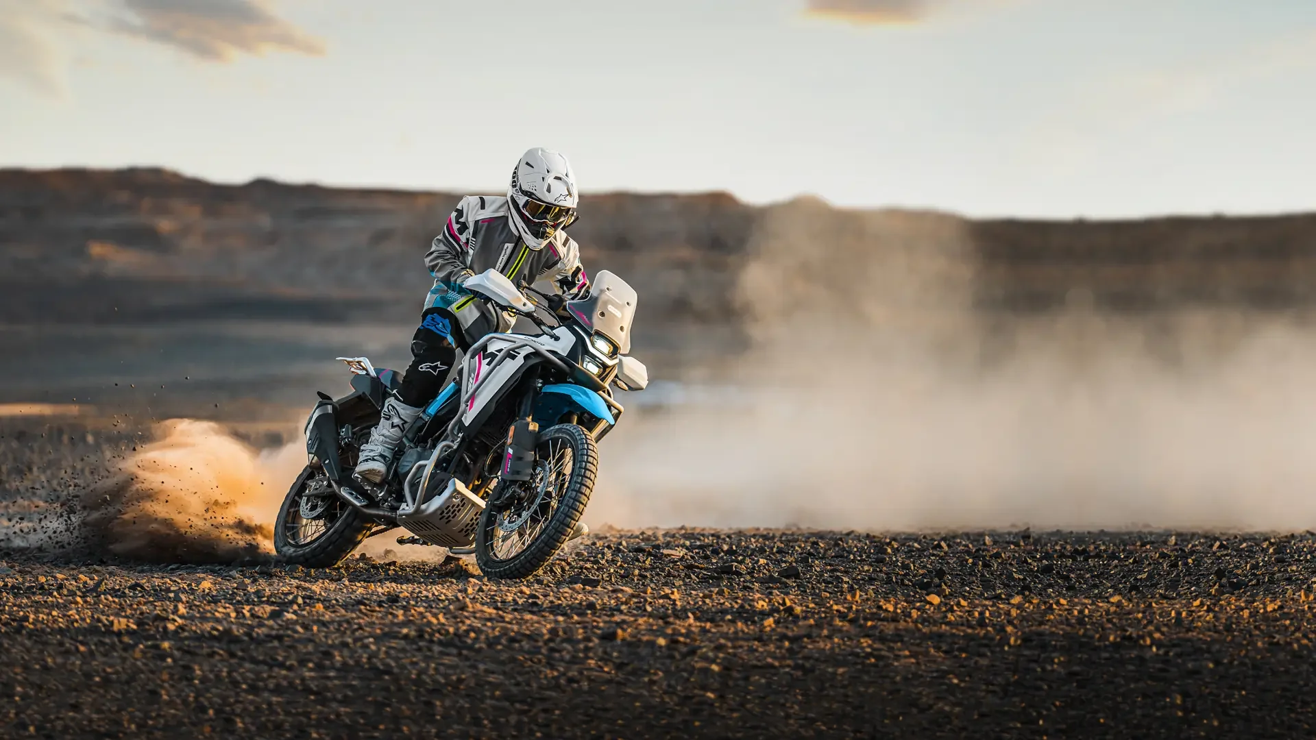 Rider on a CFMOTO adventure motorcycle in an open landscape
